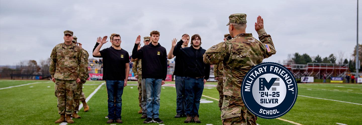 A salute between members of the military and students on the UWRF football field.