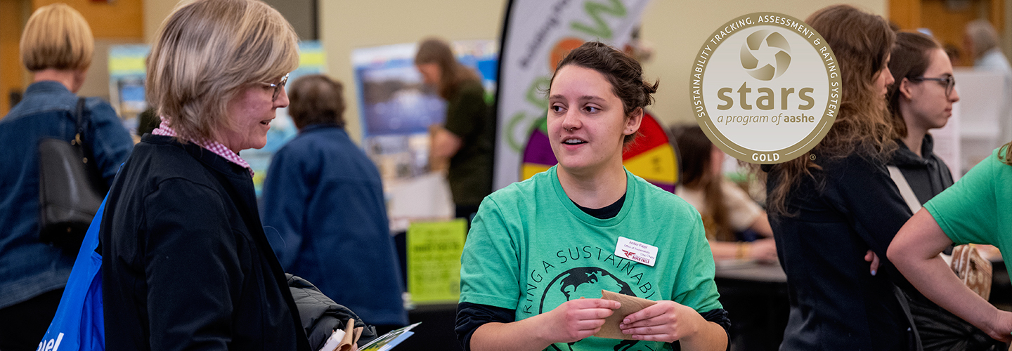 Sustainability Club member Amber Rappl speaks to a community member during Earth Fest 2024