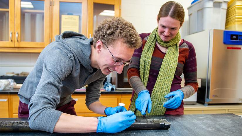 Student and professor testing soil samples in the soils lab