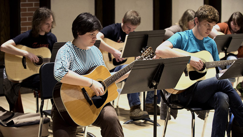 Students playing guitars