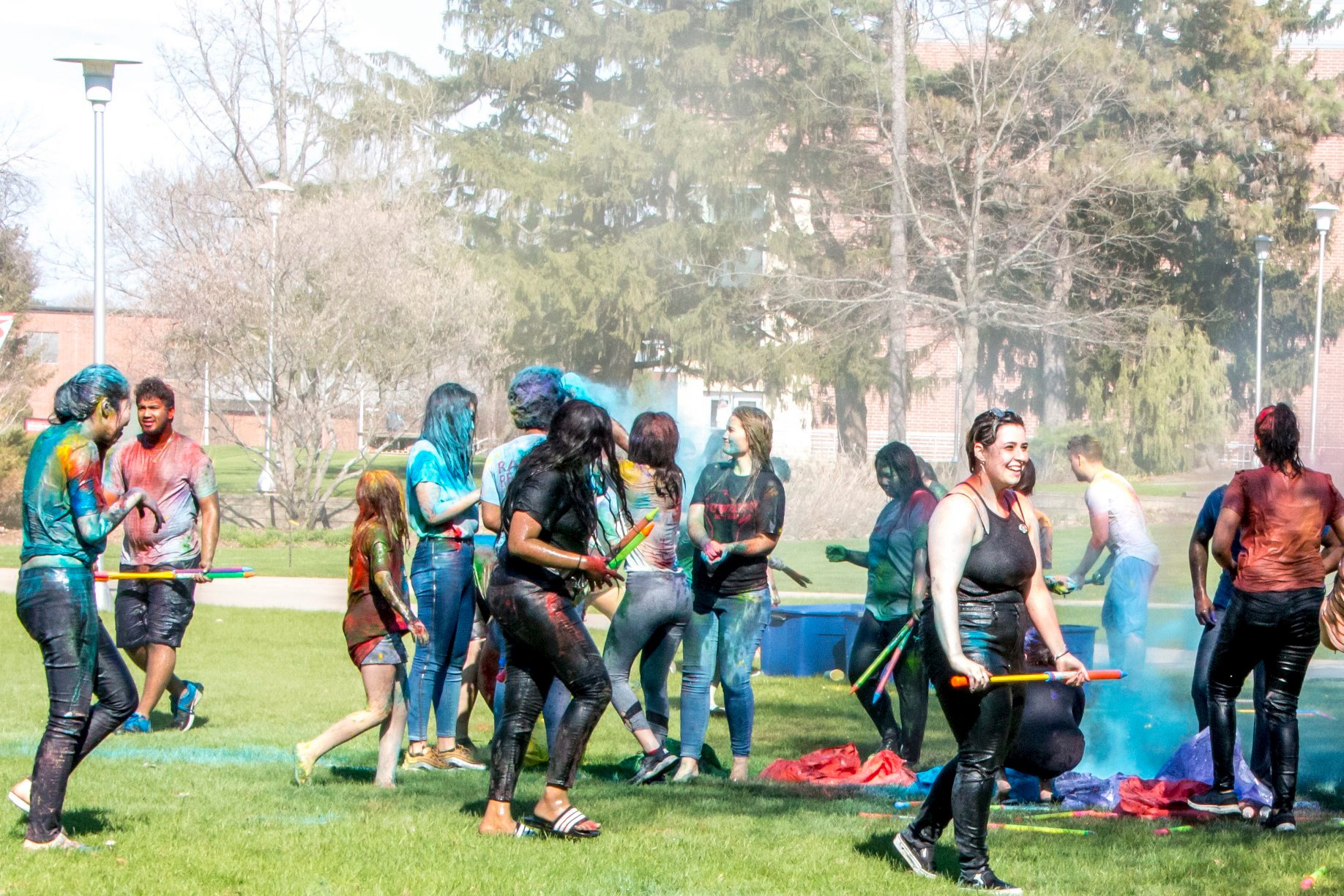 Students celebrating Holi, covered in colorful chalk powder