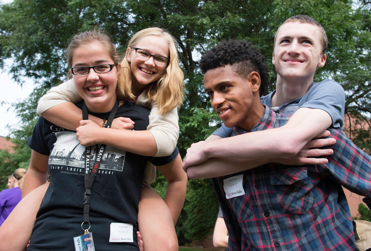 Four students getting piggyback rides from friends at Week of Welcome