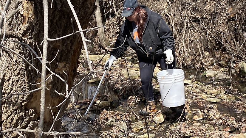 Jody Pederson, who works as groundskeeper at UW-River Falls, helps pick up trash near in a ditch south of University Center as part of Campus Clean Up Day and Earth Month