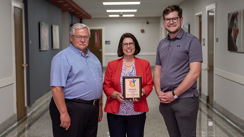 UW-River Falls Chancellor Maria Gallo receives a gold-level Family Friendly Workplace Award Thursday from Mark Tyler, left, founder of Family Friendly Workplaces, and Neil Kline, right, executive director of the organization. Pat Deninger/UWRF photo.