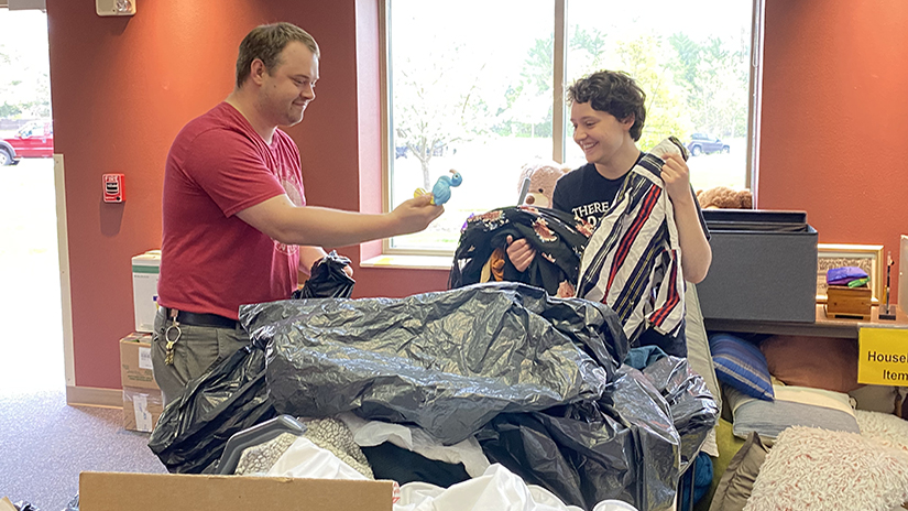 Mark Klapatch-Mathias, coordinator of the UWRF Sustainability Office, shows a toy to student Amber Rappl as they sort items donated as part of the Don’t Throw It, Donate It! project. 