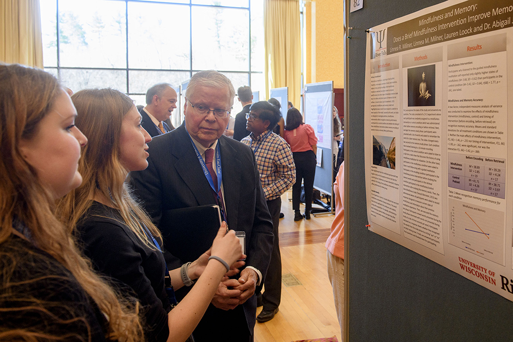 UW System President Jay Rothman converses with UW-River Falls students Lauren Loock, center, and Linnea Milner Thursday as they presented their work during the National Conference of Undergraduate Research at UW-Eau Claire.