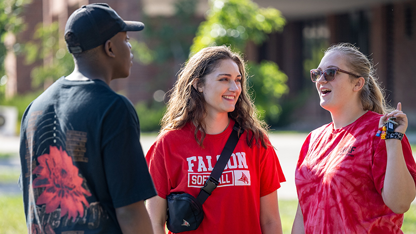 Three students standing outside talking