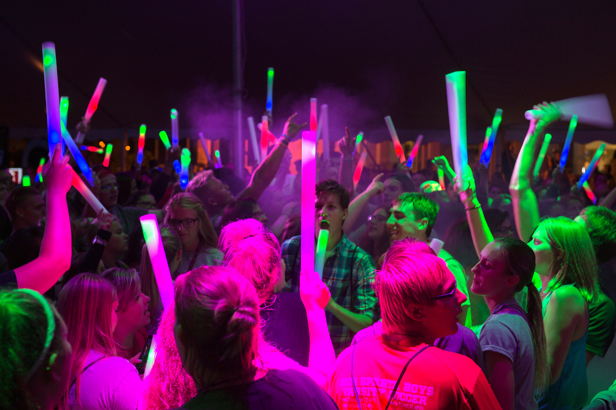 Students with glow sticks dancing in crowd