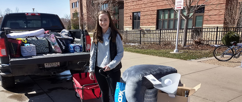 Student places belongings in vehicle
