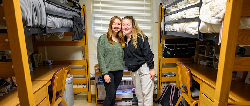 Two roommates in Crabtree stand in their room, smiling.