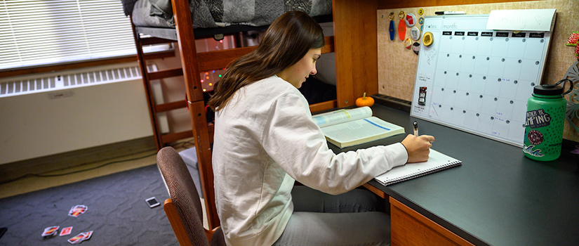 A student studies at their desk in Grimm Hall.