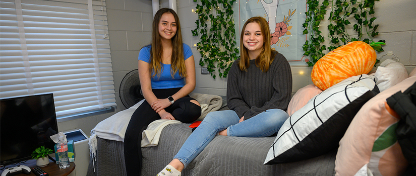 Roommates hang out on a bed in May hall