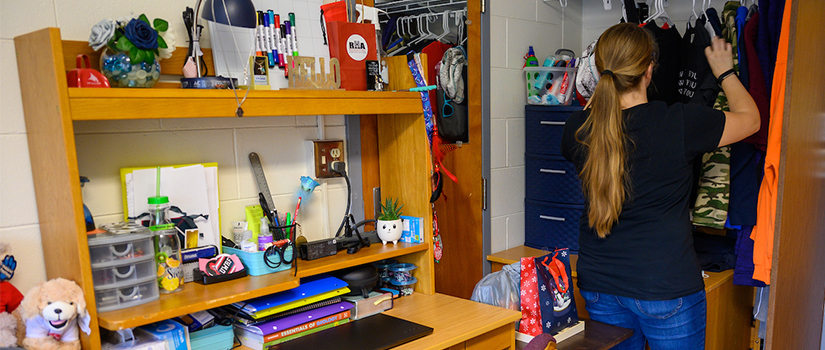 A student looks into their closet within Prucha Hall
