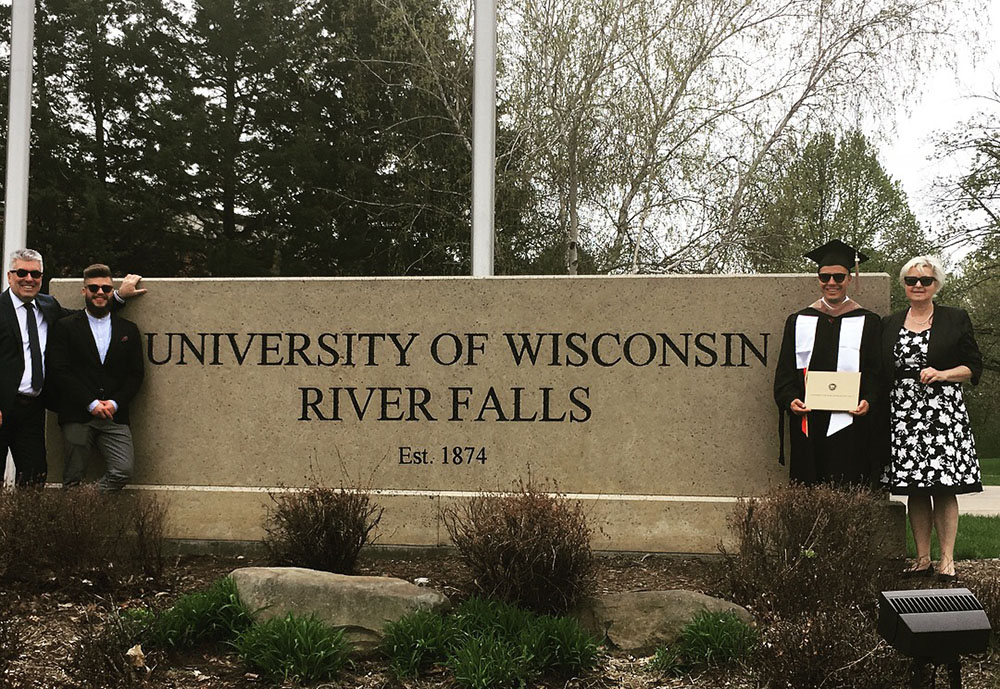MBA Graduation in front of sign