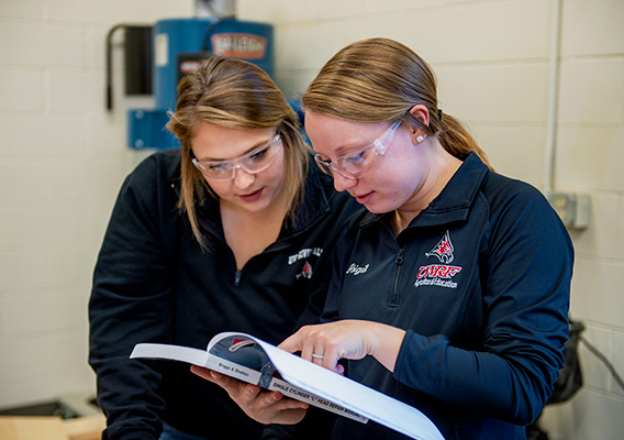 Two Agriculture Education students read a textbook