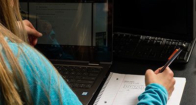 Student writes notes in a notebook