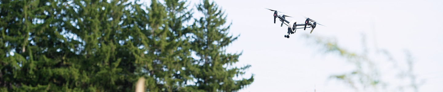 A student flying a drone to survey the crops in a field