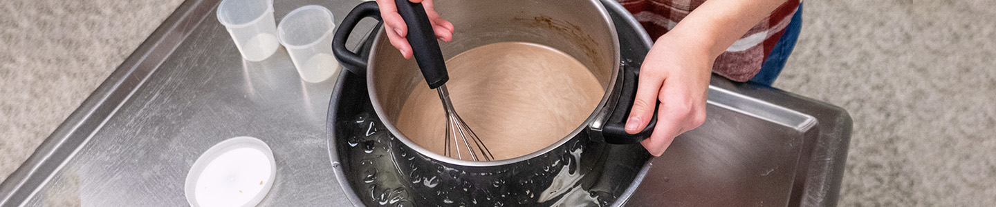 A student stirring a pot in a Food Science lab