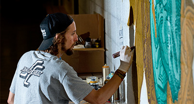 Artist painting a mural in the Centennial Science Hall