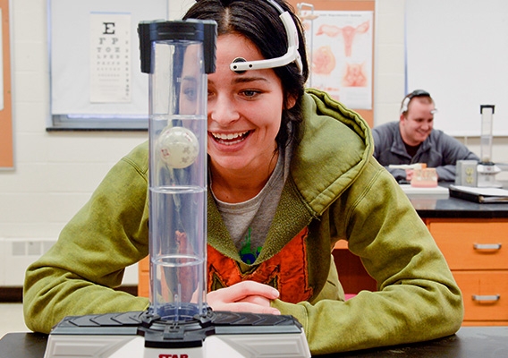 Biology student conducts an experiment during class