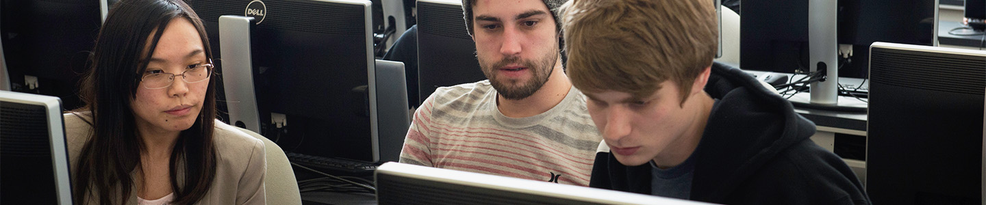 Three students looking at a computer screen in a Business Administration class