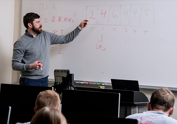 Professor conducts a lecture using a whiteboard