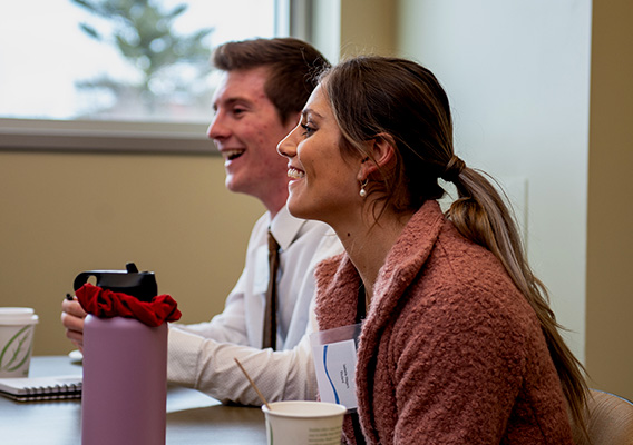 Two students listen to feedback during a business pitch