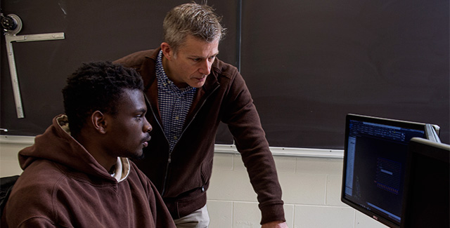 Professor views a document on a student's computer screen