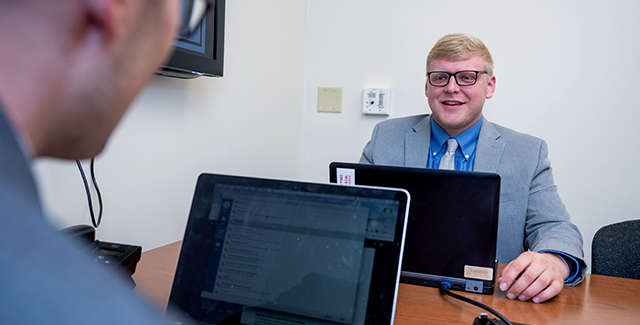 Two students participate in a mock meeting in the sales lab