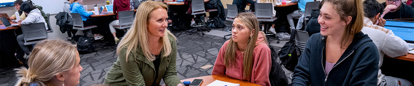 Health and Human Performance professor talks to a group of students during class