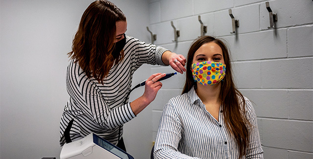Communication Sciences student inspects the ear canal of another student
