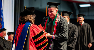 Honors student shakes hands with the Chancellor as they cross the stage