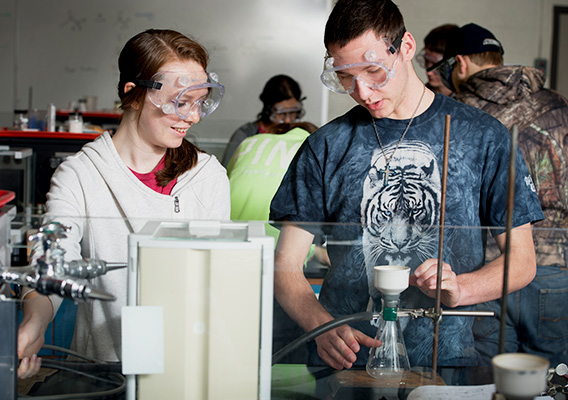 Two Chemistry students conduct an experiment during class