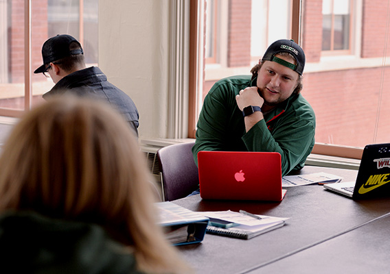 Business student discusses coursework with another student in class