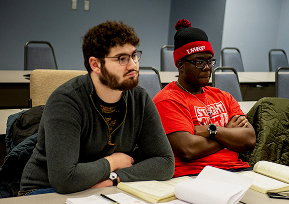 Two students listen to their professor during class