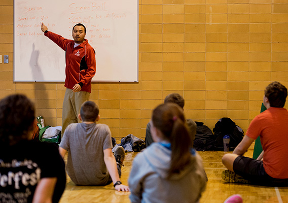 Student coach points to information on whiteboard during class