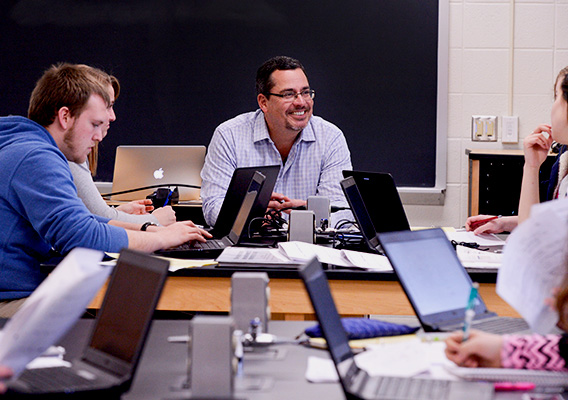 Computer Science professor casually talks with students during class