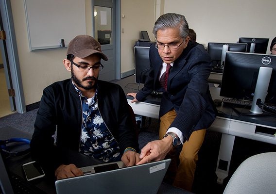 Computer Science professor points to a students laptop screen