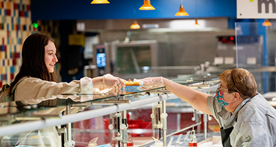 Student receiving a plate in the dining hall