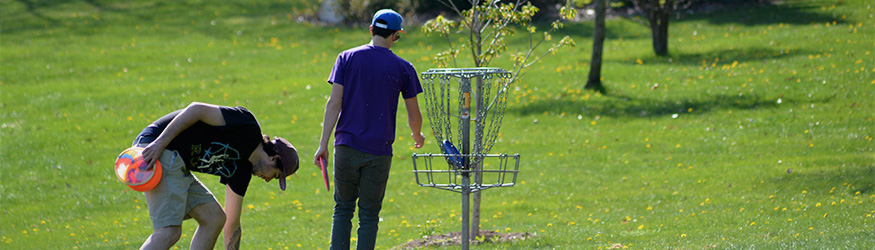 Two students play disc golf