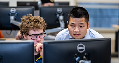 Student and professor looking at computer screens in CAD engineering lab