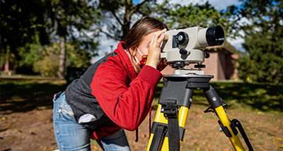 Environmental Engineering student using surveying equipment during class