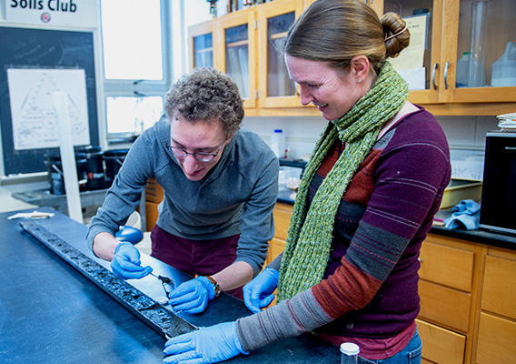 Two students conduct experiments on soil during a class