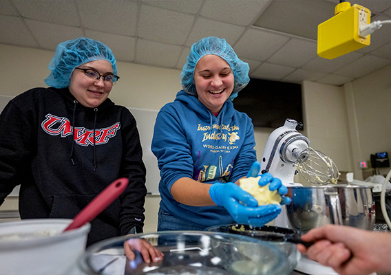 Food Science students mix ingredients to make butter during lab