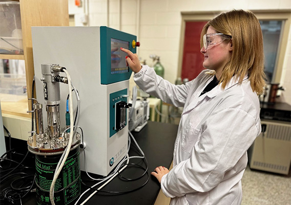 Food Science student calibrates a machine in a lab
