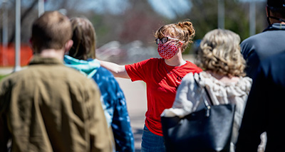 Falcon Guide leads a group of people on a tour of campus