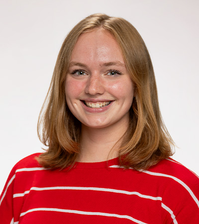 Headshot of Hanne Johnson, a young woman with light brown hair wearing a red and white striped shirt