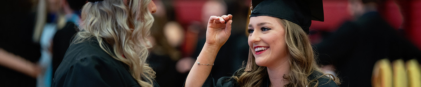 Two students prepare for the commencement ceremony