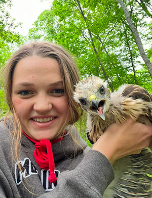 Bekah VanEperen poses with a baby hawk