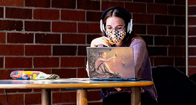 Student studies on their laptop in the campus library